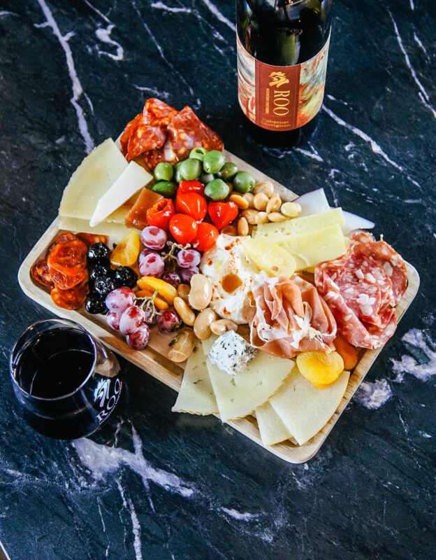 a delicious charcuterie board and a glass of wine