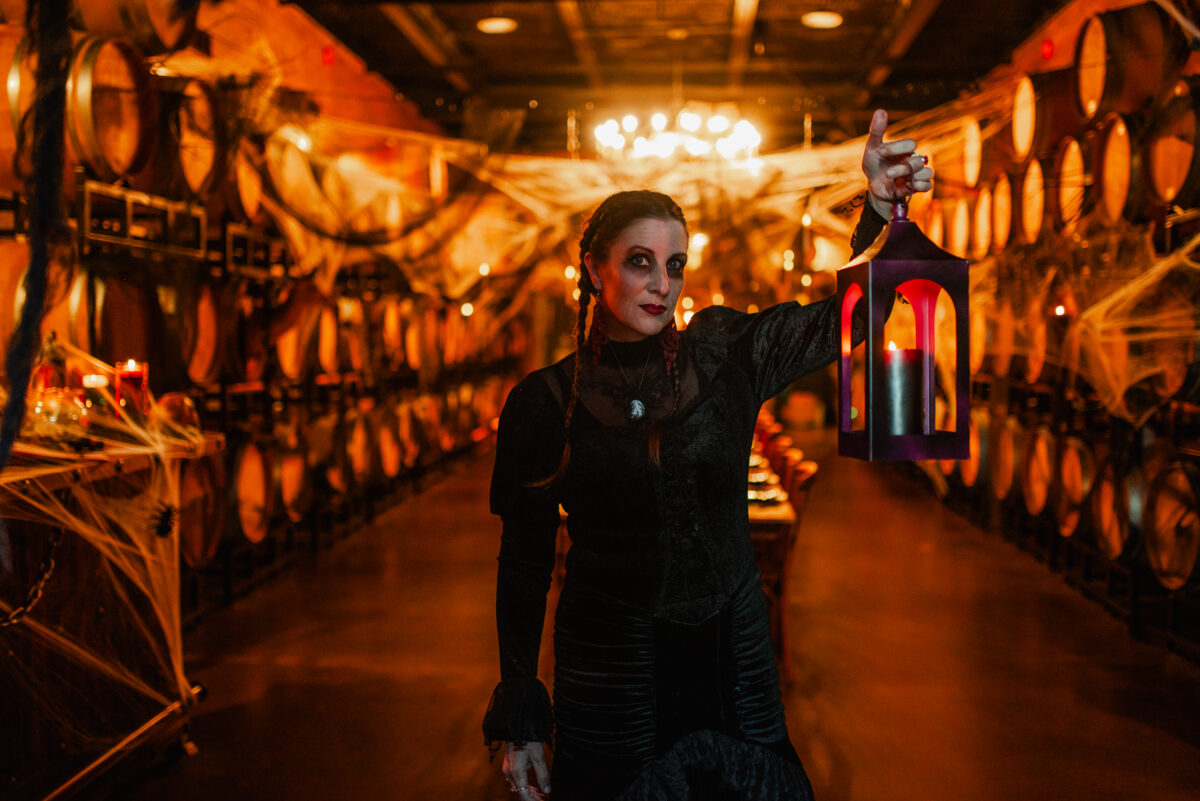 a woman holding a lantern in the barrel room